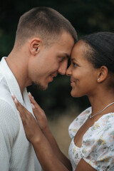 Fototapeta premium Affectionate moment of an interracial couple, close-up portrait of love, joy and authentic emotions.