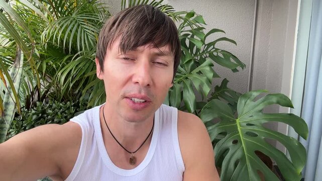 homem falando para c&acirc;mera no jardim 