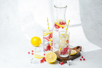 Refreshing drink with lemon slices and red berries served in clear glasses with yellow striped straws