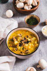 Cheese mushroom soup with herbs in a bowl on the table vertical view