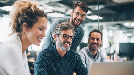 Four professionals engage in a collaborative work session at a contemporary office. They focus on a laptop while discussing ideas and sharing smiles in a productive atmosphere.