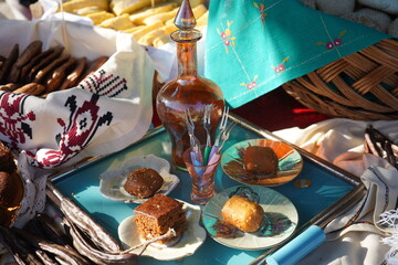 A rustic Cretan feast with carobs, rakomelo or liqueur and various traditional homemade sweets. The setting is rich in textures, colors and a warm, authentic atmosphere.