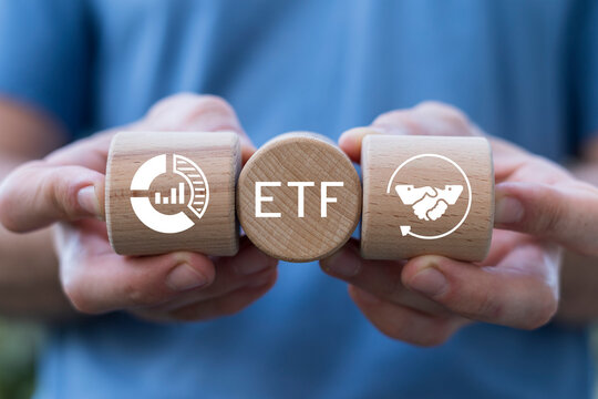Person holding wooden blocks with icons sees acronym: ETF. Analytics of ETF data, stock charts, financial market investment concept. Buying strategic ETF Exchange traded fund stock market trading.