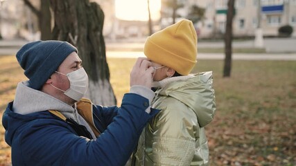 man child put medical face masks park. protection against coronavirus pandemic omicron delta strain. modern family walk. loving child hugging father park. kid love parent. dad talking little daughter - Powered by Adobe