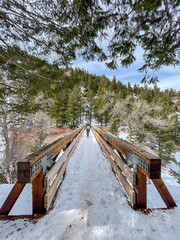 Women walking on wooden bridge in the snowy Colorado mountains, Rocky Mountains 