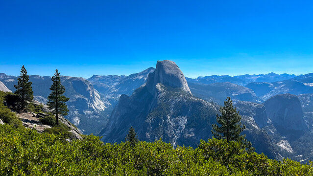 mountain landscape with blue sky, view of Yosemite Valley including Half Dome from Glacier Point, in Yosemite National Park in the western Sierra Nevada Mountains of Central California, USA - Powered by Adobe