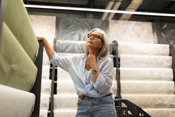 Fototapeta premium Woman shopping for home decor materials in a modern store, contemplating her choices on a weekend afternoon