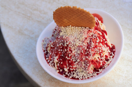 Traditional German spaghetti ice cream dessert made of vanilla ice cream and stawberry sauce