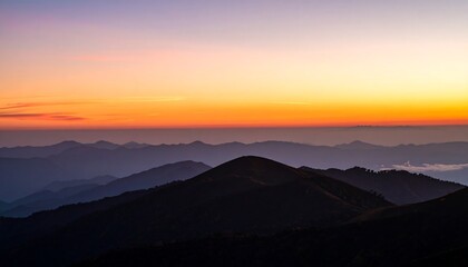 A majestic vista of layered mountain ranges bathed in the warm hues of a sunrise.