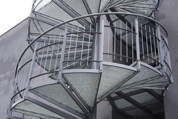 Spiral staircase design featuring metallic structure in urban environment during daylight hours