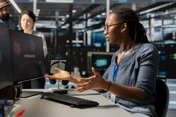 Woman working in server farm perturbed by malicious threats detected by cybersecurity systems. Stressed data center system administrator worried after detecting irregular network activity patterns