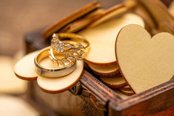 wedding rings on a wooden box with wood hearts