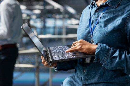 Server farm engineer managing storage arrays supporting machine learning for system management workflow. Technician on industrial platform handling AI processing tasks, programming. - Powered by Adobe