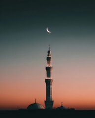 A Serene Image of an Islamic Mosque’s Minaret Rising Against Sunset with a Crescent Moon