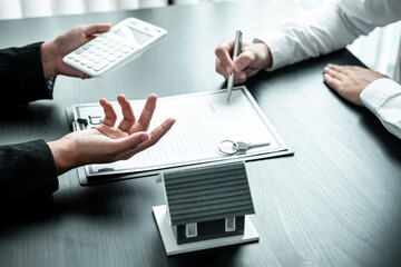 Sale Estate agent are presenting home loan to customer to decision signing contract to rental house insurance with approved property form