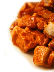 Close up of marinated pork belly bits on white background. Asian style food for cooking on a barbeque or oven. Ready to cook product. Red sweet chilly and honey marinade for pork belly slices.