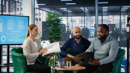 Diverse business leaders greeting each other in a conference room, shaking hands and starting the negotiations for a new partnership deal. Powerful people discuss contract details. Camera B.