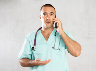 Engaged in direct telephonic conversation, male physician imparts medical insights remotely.