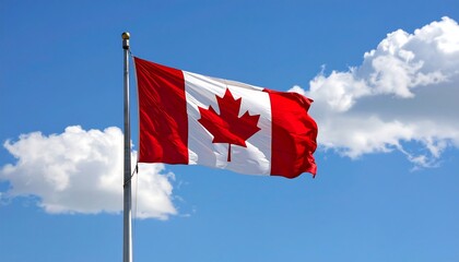 A vibrant Canadian flag billows freely against a clear, cloud-filled sky, showcasing its national colors and a symbolic maple leaf.