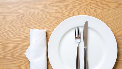A white plate with fork and knife on a wooden table with a napkin