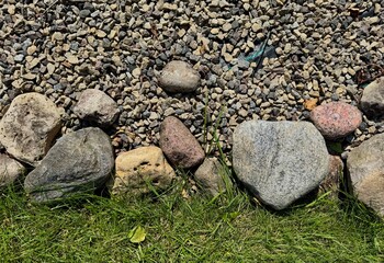  Natural stones on lush green grass creating textured outdoor background 