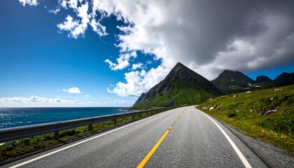 Naklejka premium Winding road leading to the sea, under a partly cloudy sky