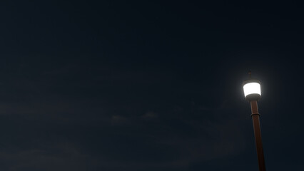 Vintage street lamp glowing and lighting the night under a dark sky.