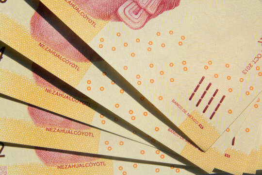 Acercamiento a billetes mexicanos de 100 pesos, donde se puede leer BANCO DE MEXICO