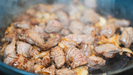Juicy cubed beef sizzling with garlic and spices in a frying pan. Perfect for cooking demos, recipe videos, or food ads. Appetizing close-up