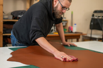 Caucasian bearded man working as a tanner in a workshop. 