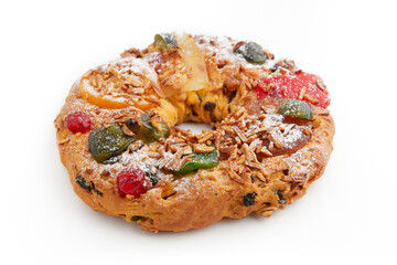 A whole round wreath-shaped cake decorated with candied cherries, nuts, and powdered sugar