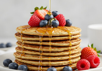 Stack of pancakes with berries and honey
