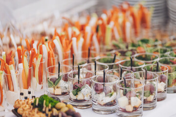 Beautifully decorated catering banquet table with different food snacks and appetizers on corporate christmas birthday party event or wedding celebration. Fingerfood - savory snacks for party buffet
