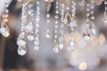 Luxurious crystal chandeliers in the middle of a forest in the glow of the sunset. Fabulous wedding decor with chandeliers. Decorating a with antique chandeliers. Light bulb in the shape of a candle.