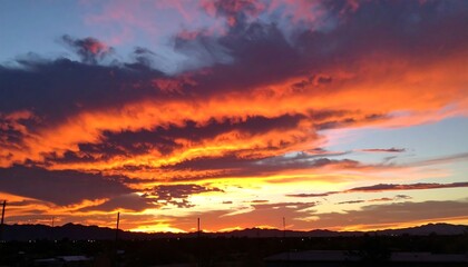 Obraz premium A breathtaking sunset paints the sky with fiery oranges, vibrant pinks, and soft purples, highlighting dramatic cloud formations.