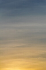 The blue and golden colors of the sky during sunset (golden hour). Colorful abstract landscape formed by clouds and sunlight in the late afternoon. Texture.