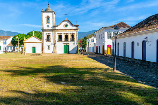 Facade of the Church of Santa Rita, built in stone in 1772. Next to it are old mansions and cobblestone streets. The streets are flooded by seawater during high tide. Historic city of Paraty, Brazil.