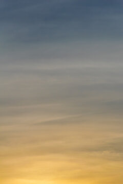 The blue and golden colors of the sky during sunset (golden hour). Colorful abstract landscape formed by clouds and sunlight in the late afternoon. Texture.