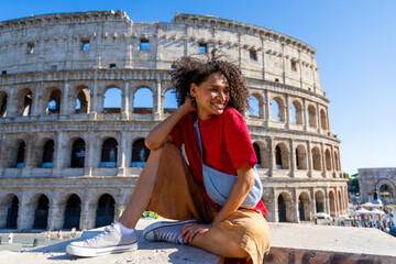 A joyful traveler poses cheerfully against the magnificent backdrop of the iconic Colosseum in Rome, capturing the true spirit of adventure on a beautifully sunny day full of possibilities