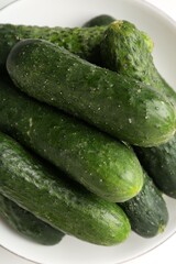 Fresh cucumbers in bowl on white table, closeup