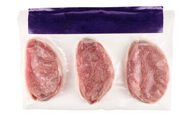 Vacuum-packed raw pork chops sealed in plastic wrap on a white background. Clean top view composition ideal for food industry, grocery marketing, packaging design or culinary content.