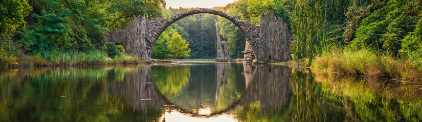 Rakotz Bridge (Rakotzbrucke, Devil's Bridge) in Kromlau, Saxony, Germany. Colorful summer, reflection of the bridge in the water create a full circle