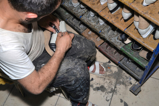 The shoemaker is making shoes in the workshop.
