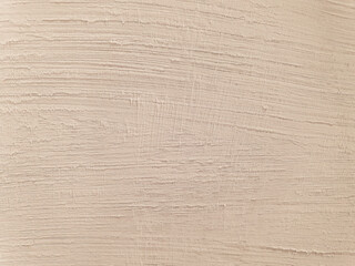 A high-resolution image of a textured wall or surface, showcasing horizontal brush strokes. The color is a light, warm beige or off-white with a subtle pinkish tint, providing a soft and inviting feel