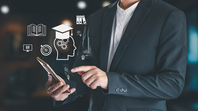 Businessman uses a smartphone to access an e-learning platform with virtual icons for knowledge, skills, and graduation on a blurred background.