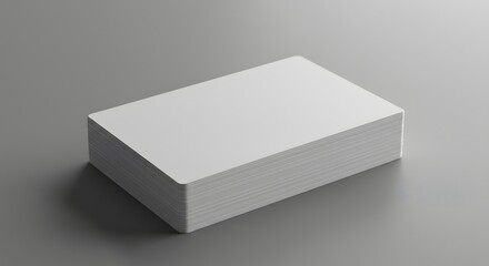 A stack of white rectangular cards with rounded corners resting on a neutral gray surface