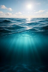 Fototapeta premium Sunlight streams through the ocean waves, creating a mesmerizing underwater scene with a clear horizon and a tranquil, tropical atmosphere