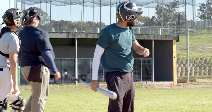Catcher signaling pitch at home plate male batter swinging bat missing, retrying swing to hit pitch