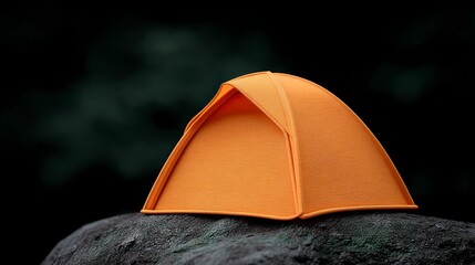 Small orange tent pitched on a dark rough rock surface with a blurred forest background