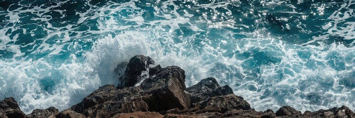 Obraz premium Ocean waves crashing over rocks.